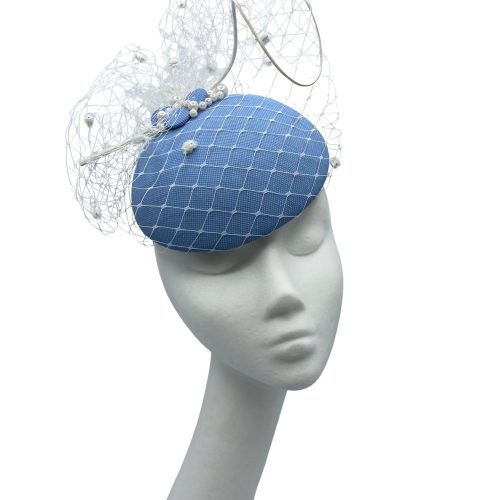 Stunning cornflower blue headpiece with white pom pom veiling overlay.